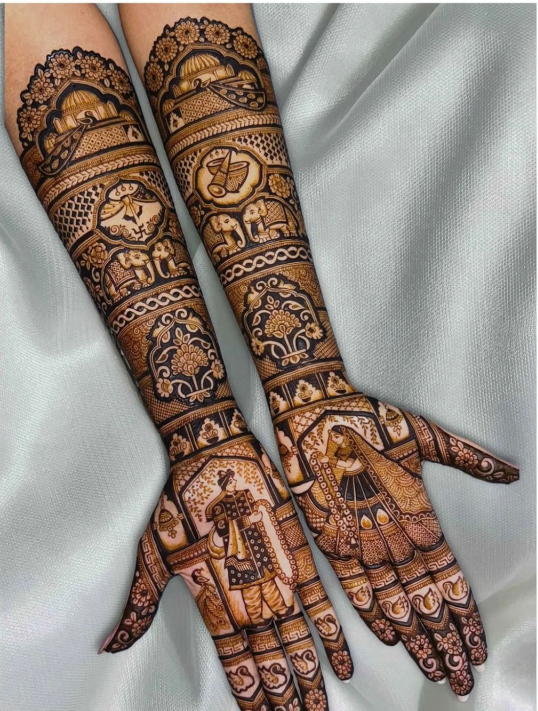 Detailed bridal mehndi with dome arches, elephants and dulha dulhan figures