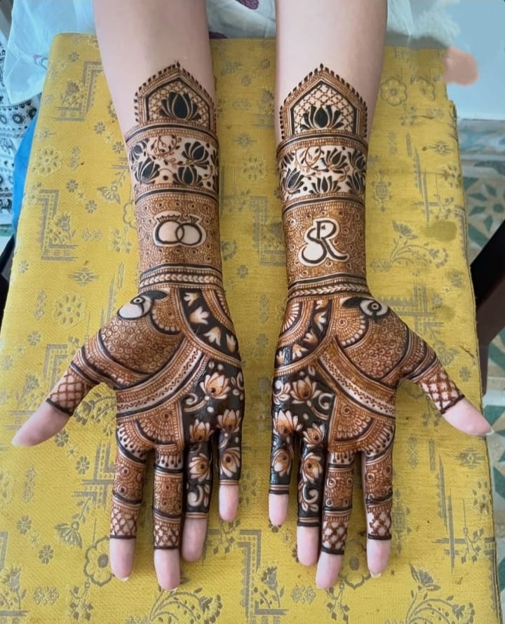 Bridal henna with lotus arch, rings and initials on forearms